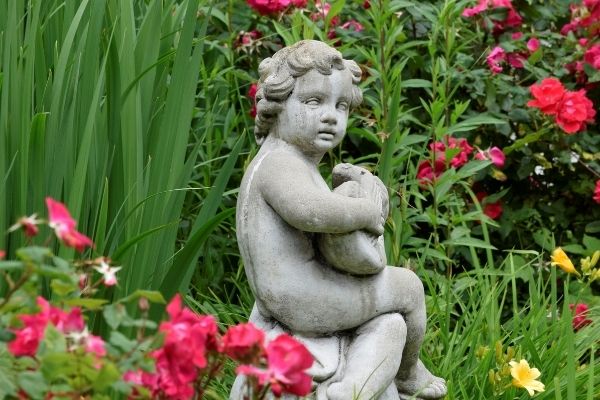 small cherub in small corner of garden